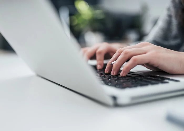 Frau schreibt am Notebook