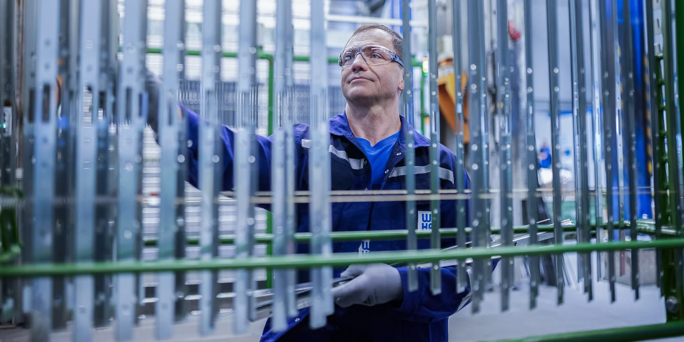 Mitarbeiter hängt Beschläge auf